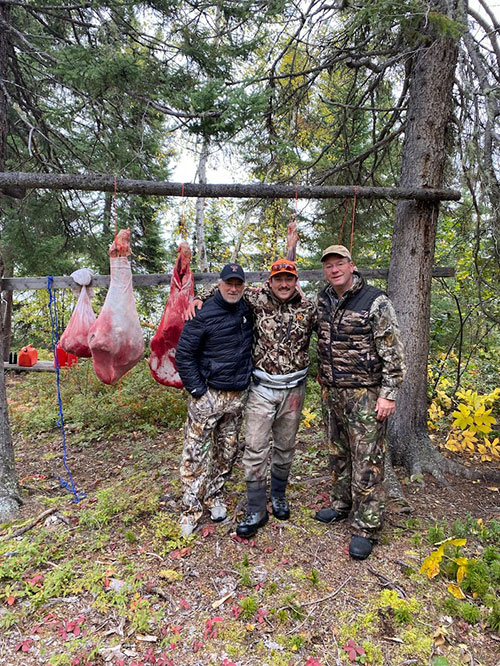 Moose hunting friends and meat pole